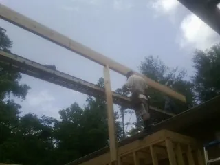 Carpenter setting a ridge beam over a new addition frame — Ice Dam Removal by Roofing Brothers in Ledgewood