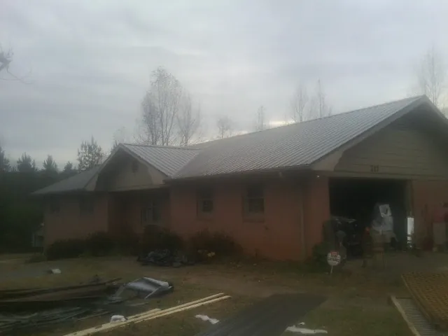 Gray metal roof on a stucco house with an attached garage in Ledgewood