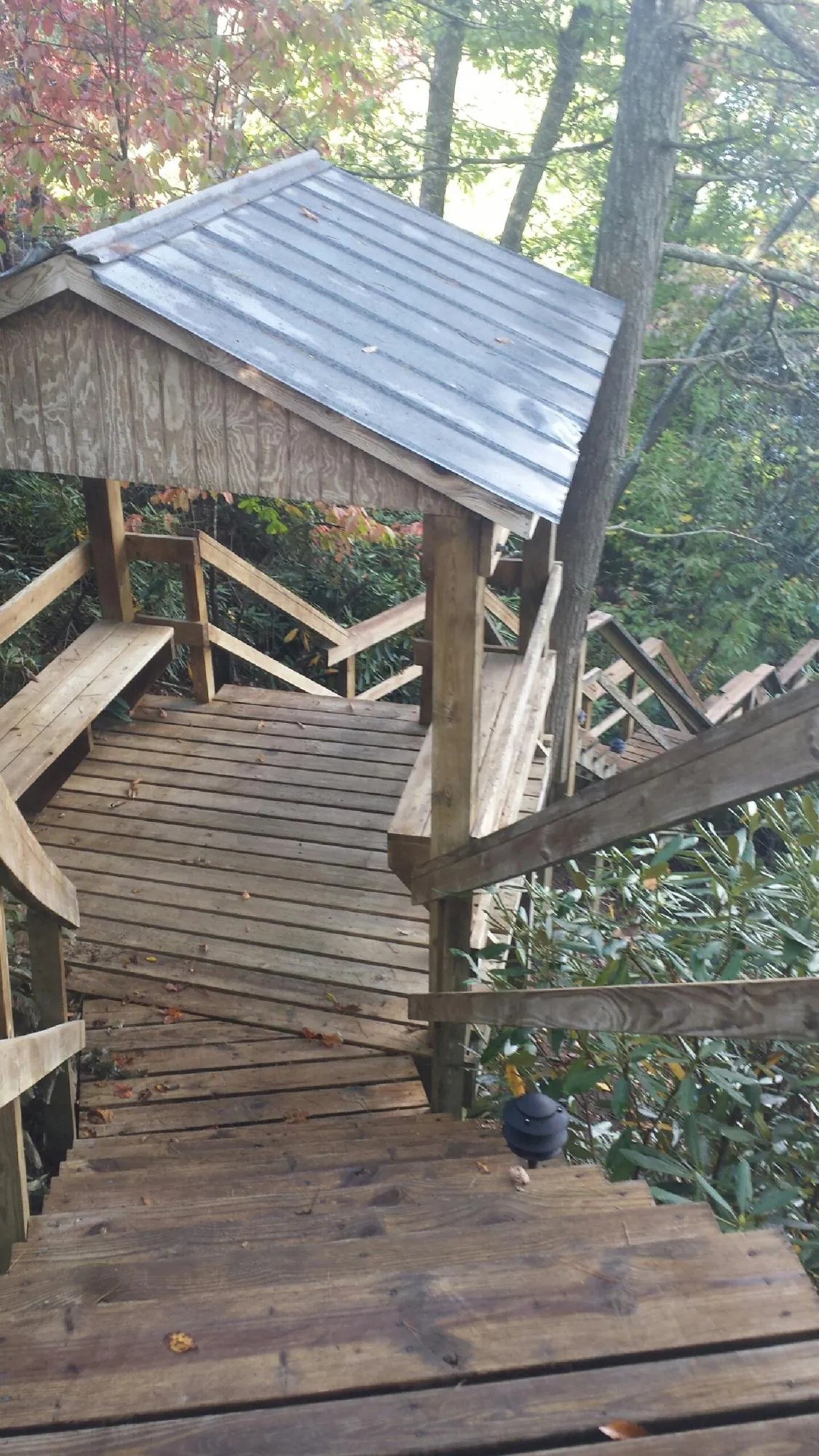 Metal roofed shelter over wooden steps on a wooded walkway — Skylight Repair & Installation work by our crew in Ledgewood